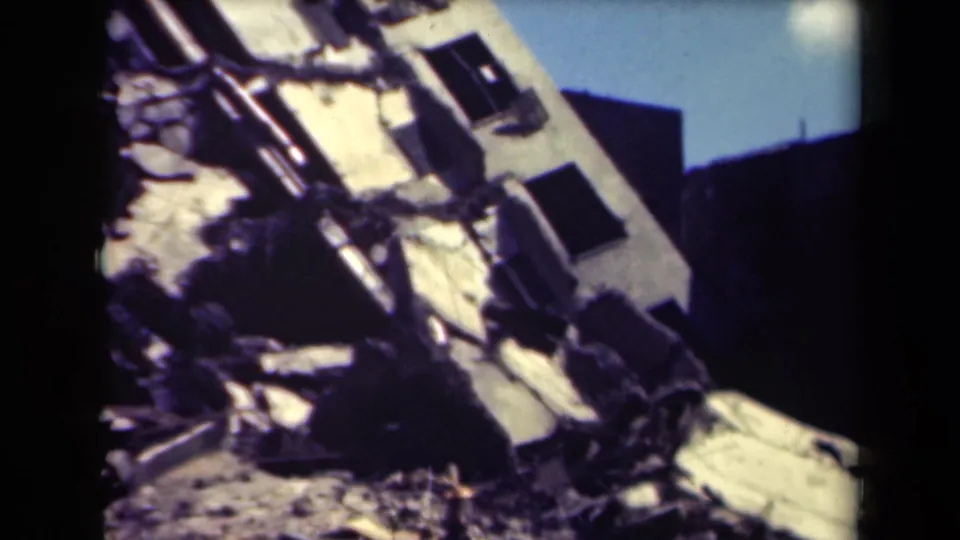 1944 Manila footage frame with a close view of collapsed concrete, broken openings, and debris from a severely damaged structure.