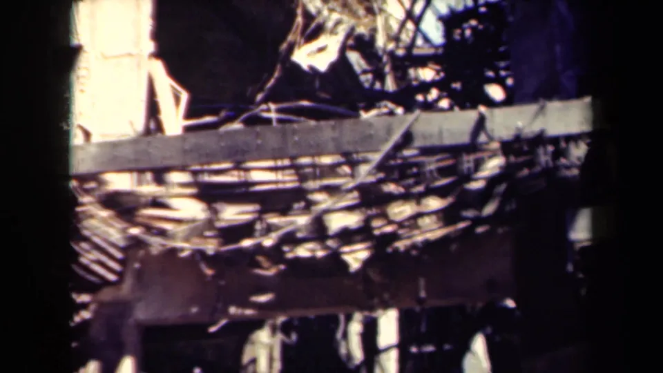 1944 Manila 8mm frame showing close, high-contrast wreckage with beams, debris, and collapsed structural surfaces.