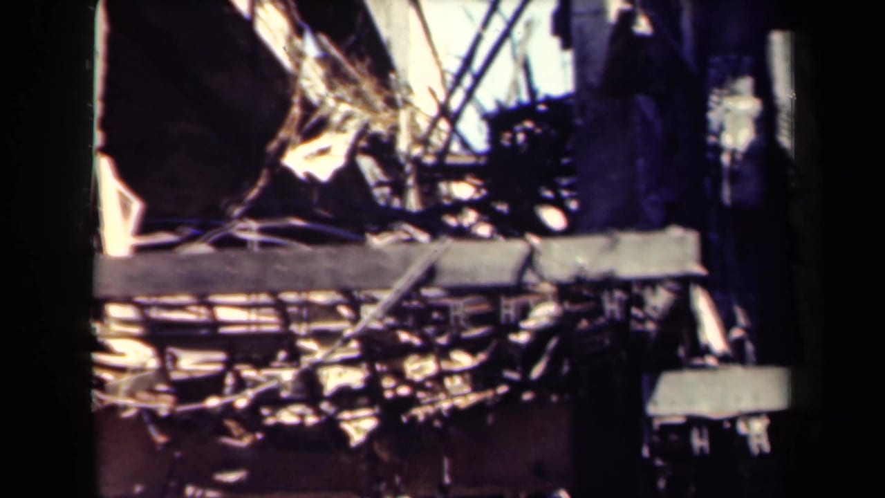 Charred debris and broken structural material inside a damaged building area.