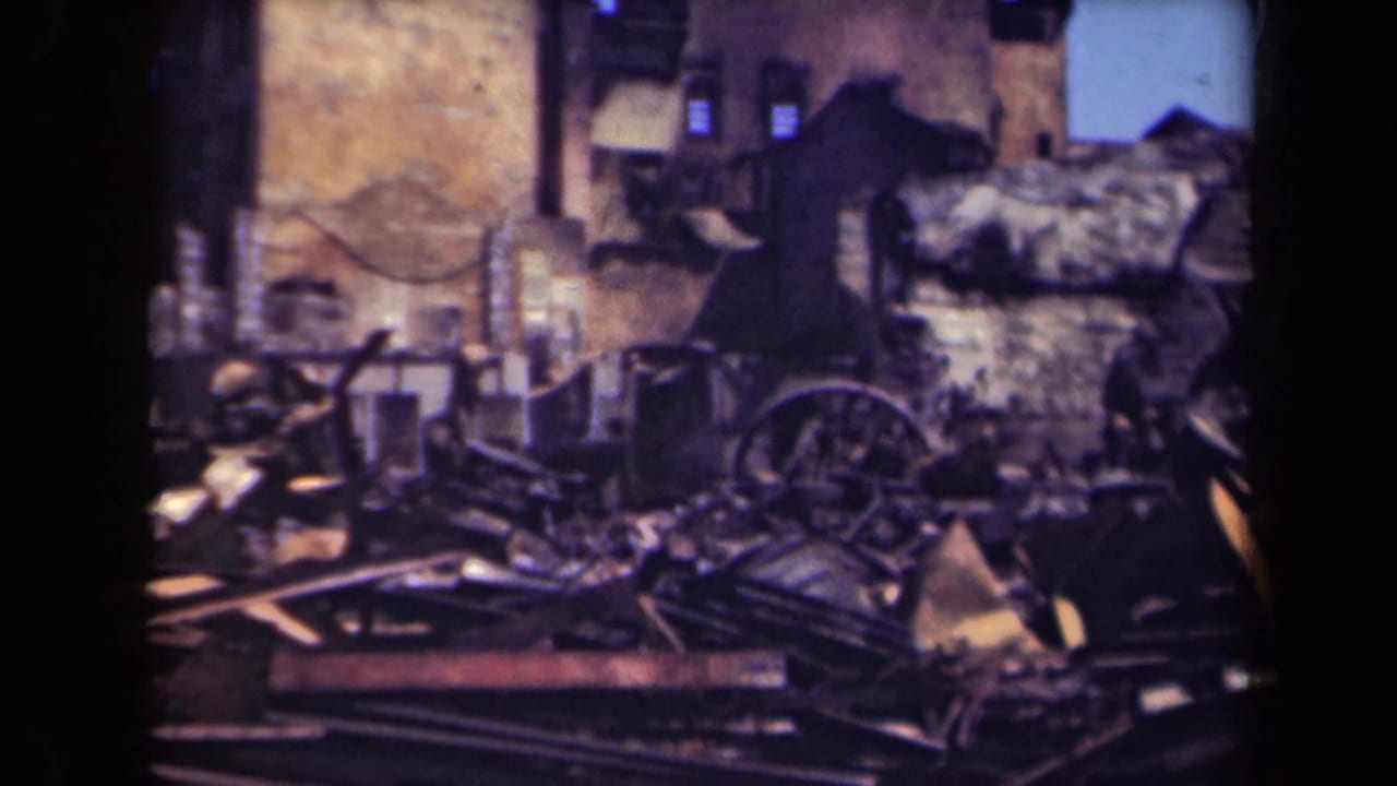 Damaged urban structure with rubble, broken timbers, and a wagon wheel.