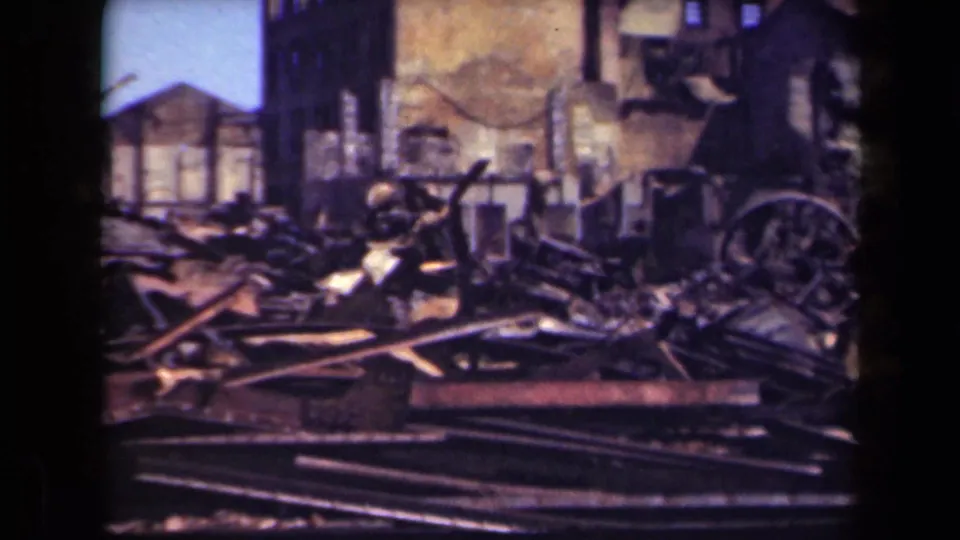 1944 Manila frame with rubble, damaged buildings, and a faded post office sign visible near the ruins.