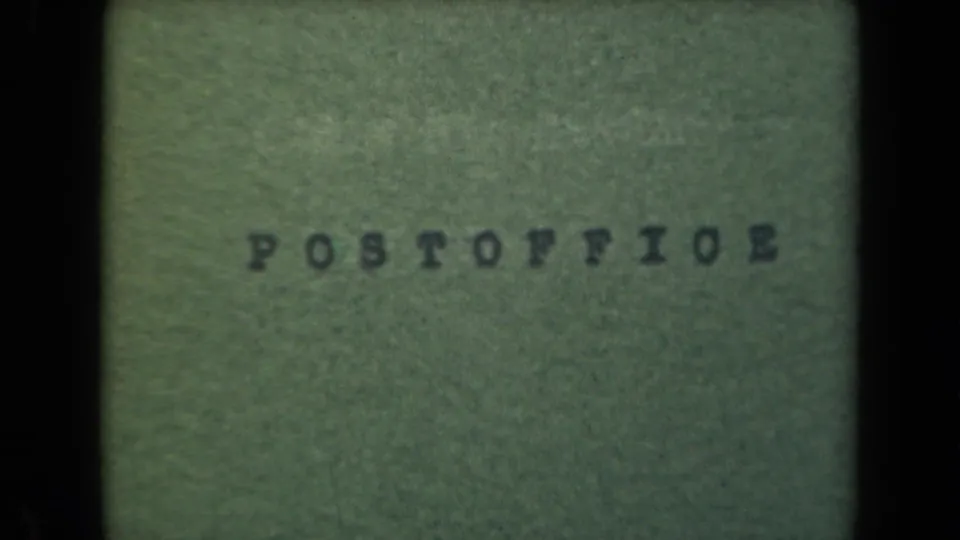 1944 Manila 8mm frame showing a green textured label or card with POSTOFFICE typed in uppercase letters and dark film edges.