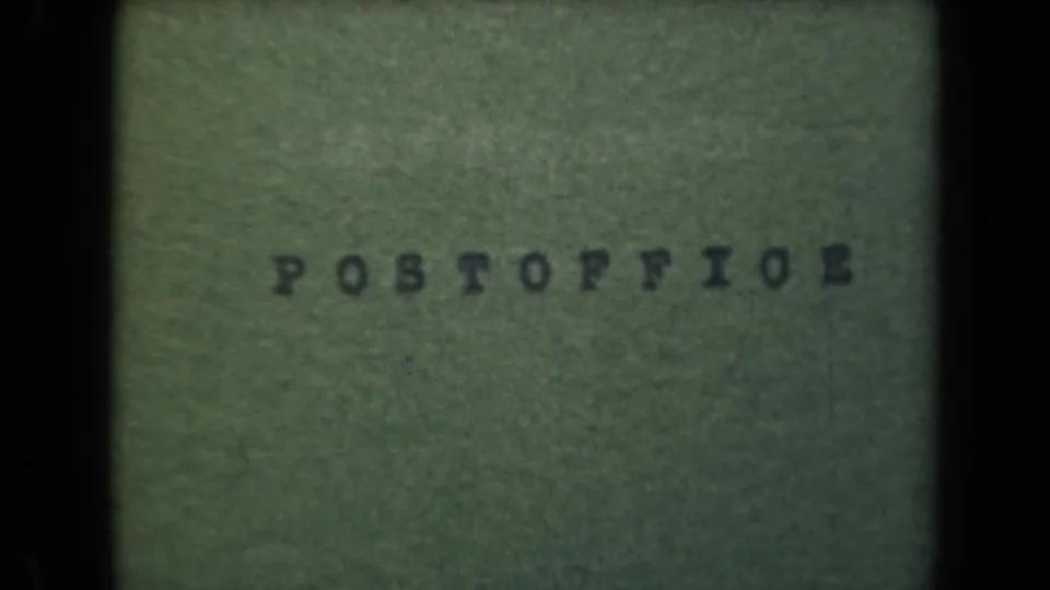 1944 Manila 8mm frame with POSTOFFICE typed on a green textured card, seen with muted color, grain, and black frame borders.