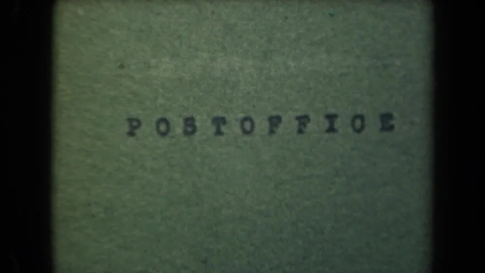1944 Manila 8mm frame showing the lower portion of a green POSTOFFICE label, with visible grain, shadowing, and frame edge darkness.