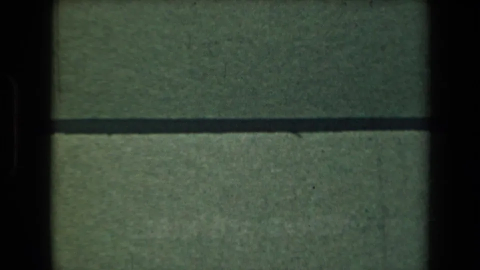 1944 Manila 8mm frame showing green textured material, a dark horizontal frame division, and the edge of the POSTOFFICE label area.