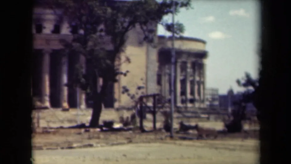 A 1944 Manila frame shows the columned facade at left, a rounded building section at right, and a quiet foreground street.