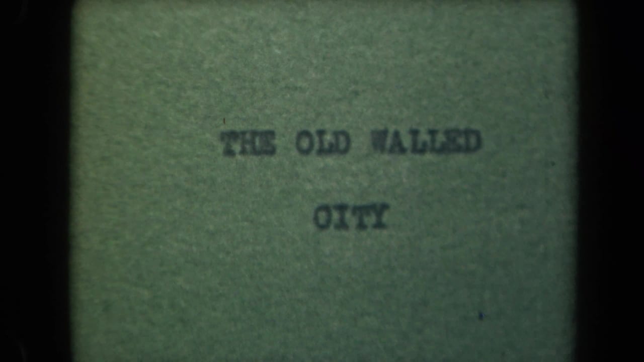 Typed title card reading THE OLD WALLED CITY on greenish paper with dark film borders.