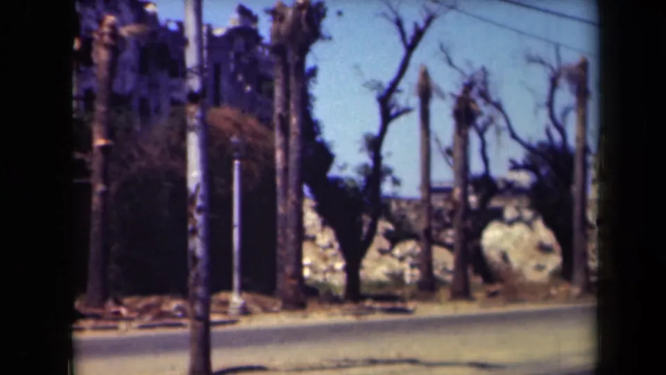 A final 1944 Manila street frame shows a damaged-looking wall, bare trees, utility poles, and a blurred passing figure or object near the road edge.