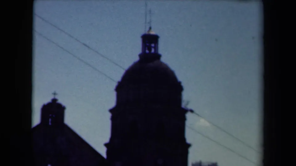 The Manila church exterior remains mostly in silhouette, with the dome, small tower, wires, and dark architectural edges visible.