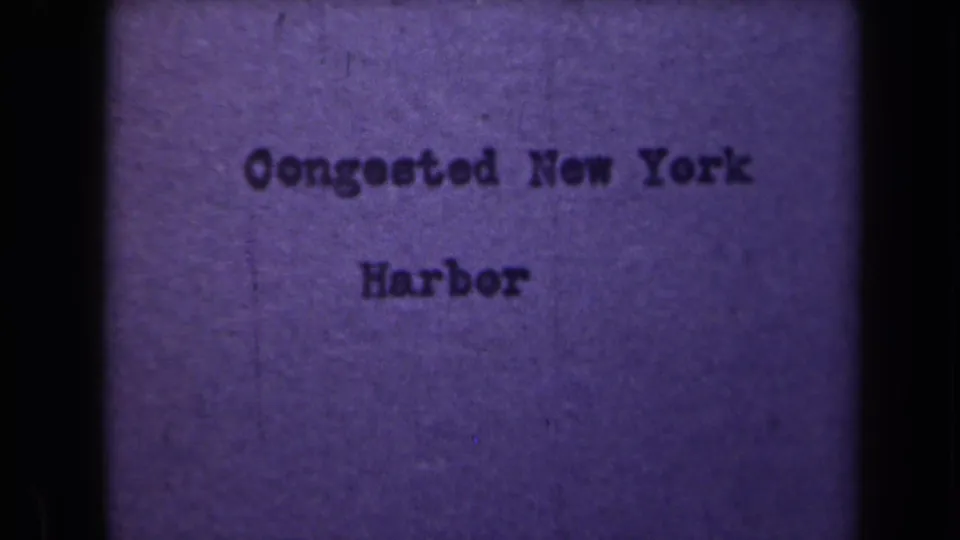 The title card continues, slightly shifted within the 8mm frame, with visible grain and a vertical mark near the left side.