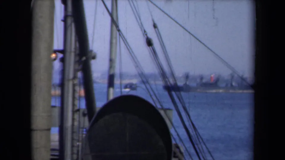 1946 New York harbor traffic seen from a vessel, with rigging, a rounded deck structure, and distant boats on the water.