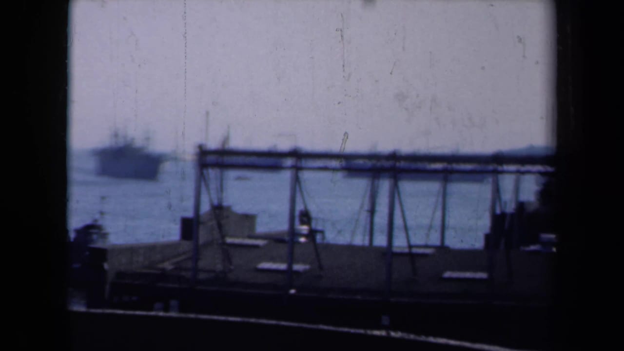 1946 New York harbor view with a large ship on the water, foreground dock structure, and dark framing at the edges.