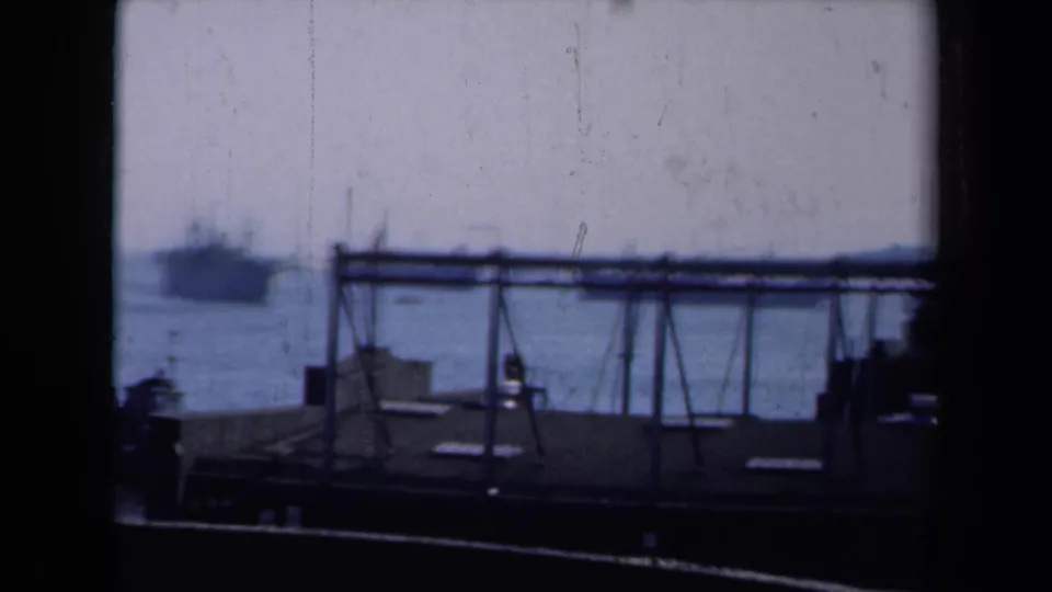 1946 New York harbor view with a large ship on the water, foreground dock structure, and dark framing at the edges.