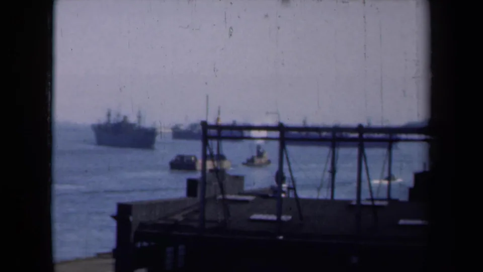 1946 New York harbor scene with small boats near the dock and larger vessels farther offshore.