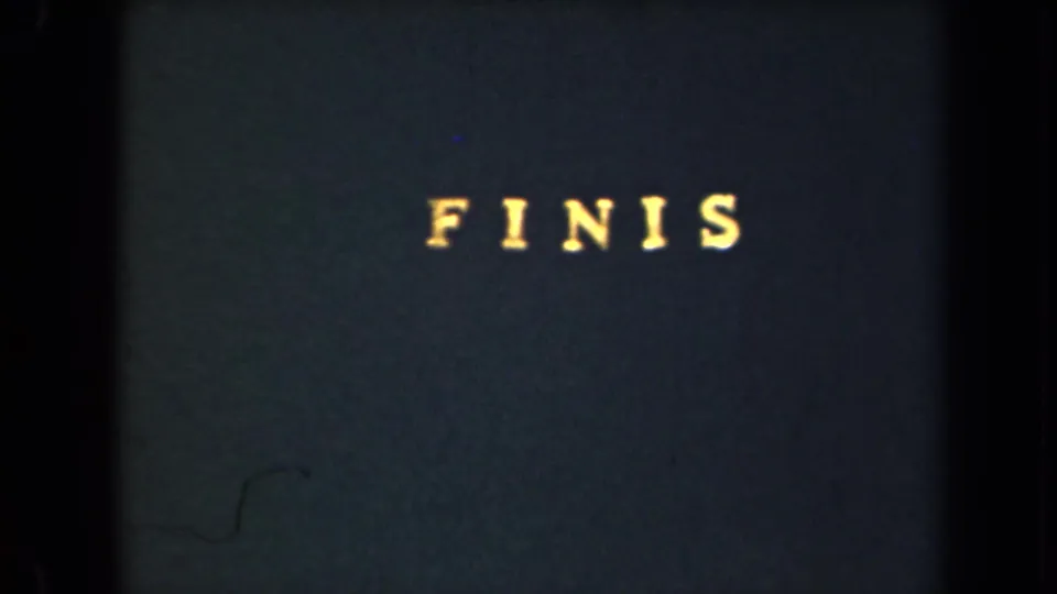1946 8mm frame from New York showing a centered “FINIS” title on a dark card with visible film texture.