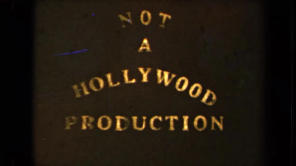 Final 1946 8mm title-card frame showing darker exposure, gold lettering, grain, and blue scratch marks.