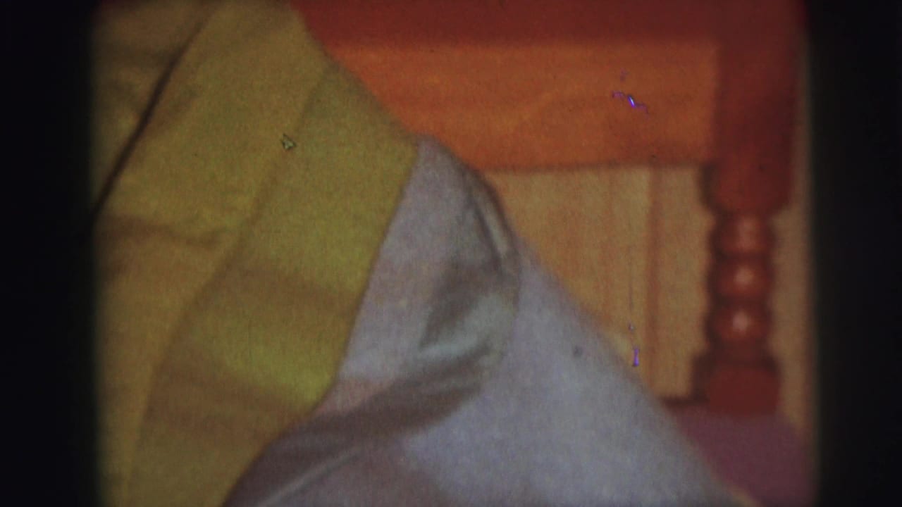 Close view of green and pale blue bedding against a wooden headboard.