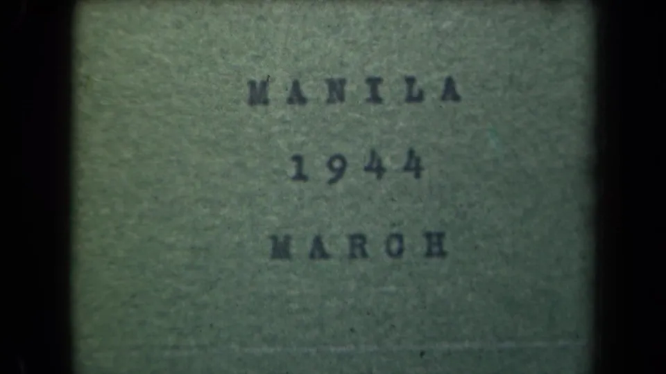 1944 Manila 8mm title card with typed text reading MANILA 1944 MARCH, seen through grain, soft focus, and dark gate edges.