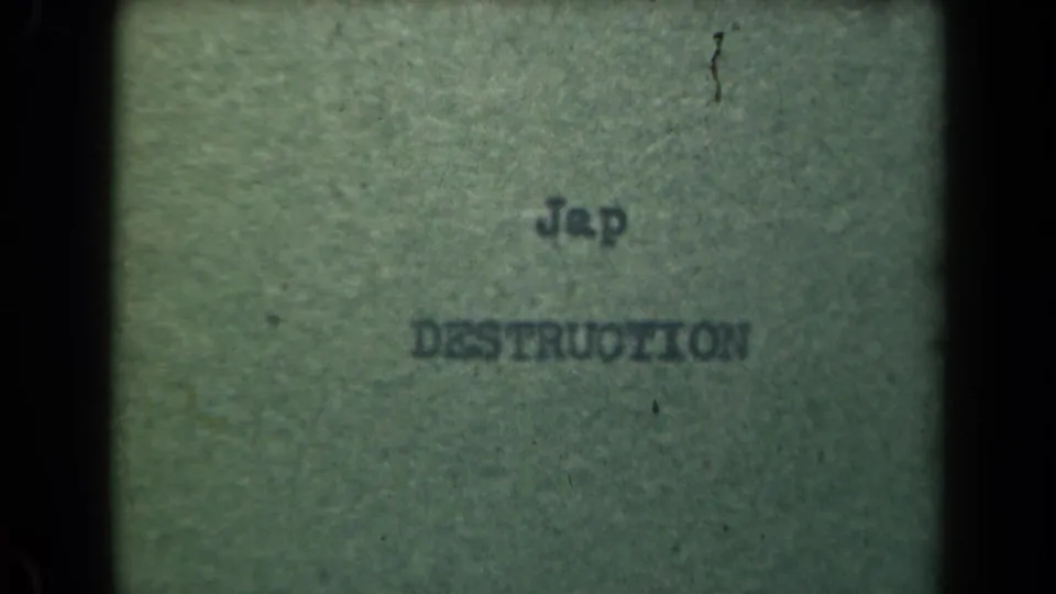 Final close-up frame of typed wartime wording on paper, bordered by dark 8mm edges and visible dust marks.