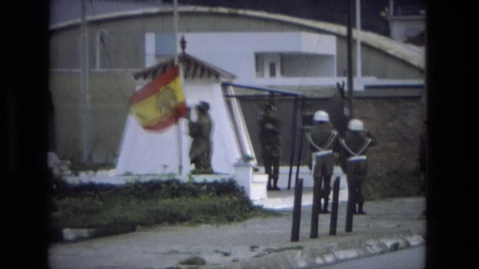 Final 1978 Andalusia frame with the Spanish flag lowered nearer the post while uniformed soldiers maintain ceremonial positions.