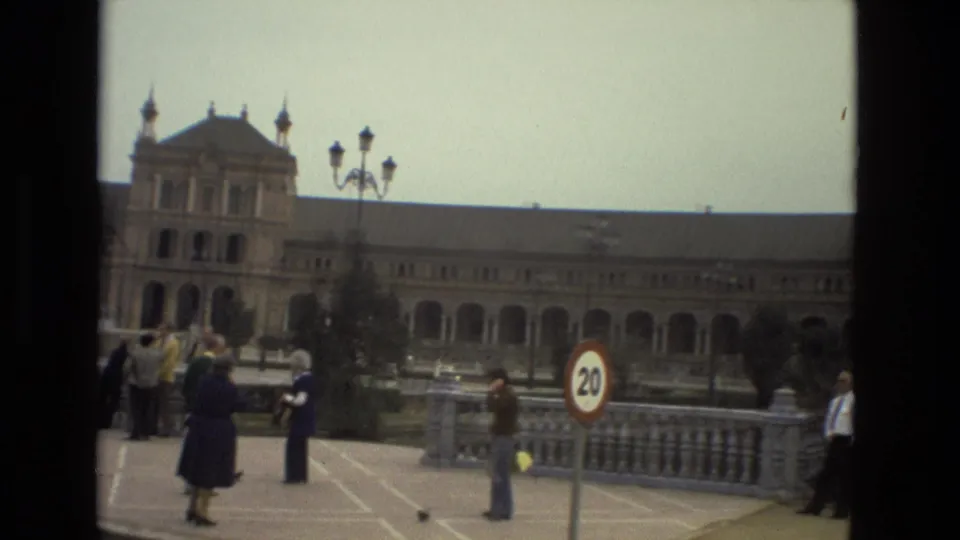 Andalusia street scene from 1978 with pedestrians, a 20 km/h sign, stone balustrade, and a historic arched building beyond.