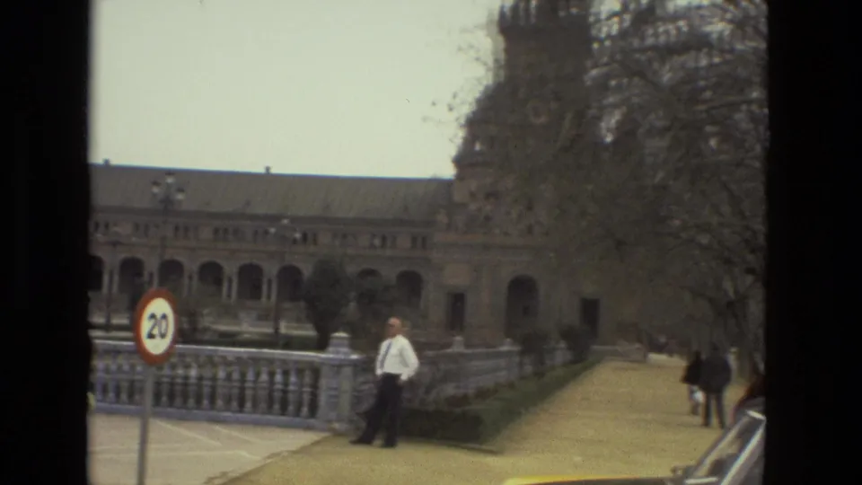 1978 Andalusia 8mm frame showing a 20 km/h sign beside a road, pedestrians, bare trees, and part of a historic building.