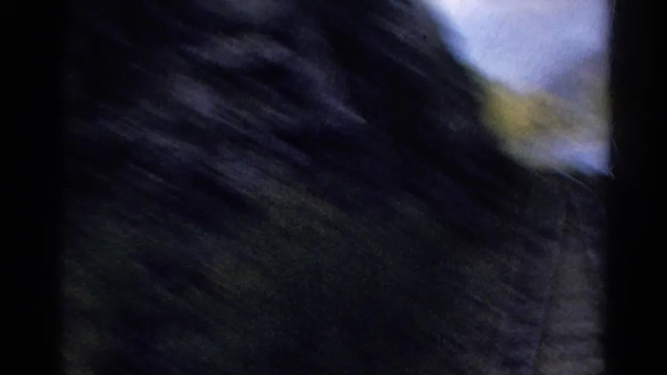 Motion blur obscures a close rocky slope or canyon wall as the train passes near the terrain.