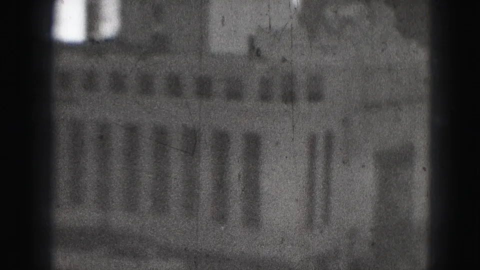 Blurred 1946 Harrisburg 8mm frame showing a large urban building facade with rows of windows and heavy film grain.