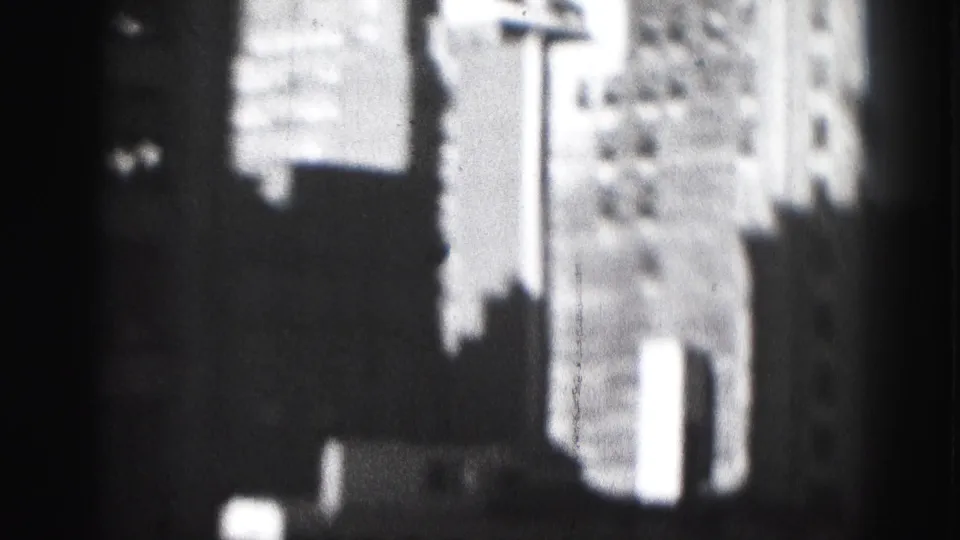 1946 Harrisburg home-movie frame showing blurred downtown building facades through a dark obstructing edge.