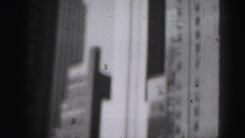 Soft 1946 Harrisburg frame showing pale high-rise walls and a dark vertical foreground band, with film dust visible.