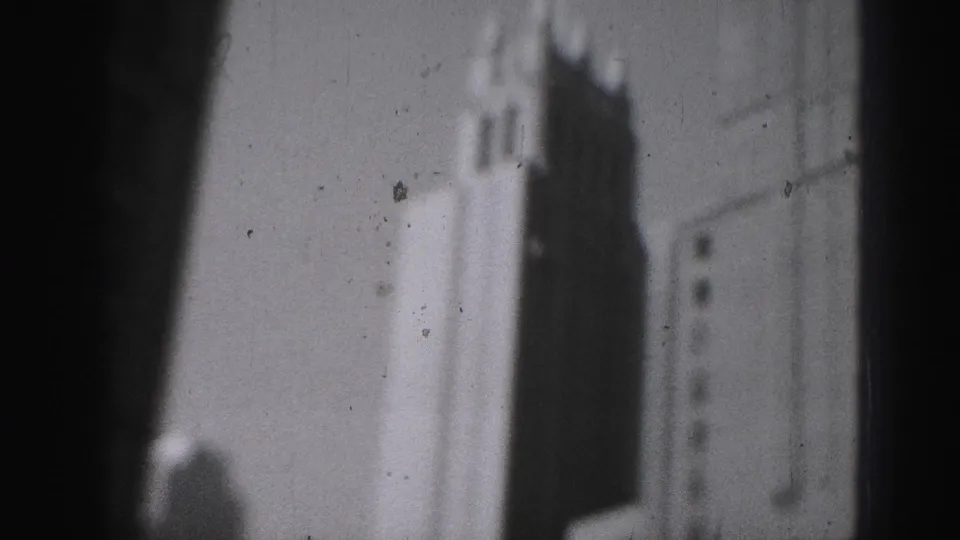1946 Harrisburg 8mm frame showing blurred tall urban facades and deep shadow from an elevated city vantage.