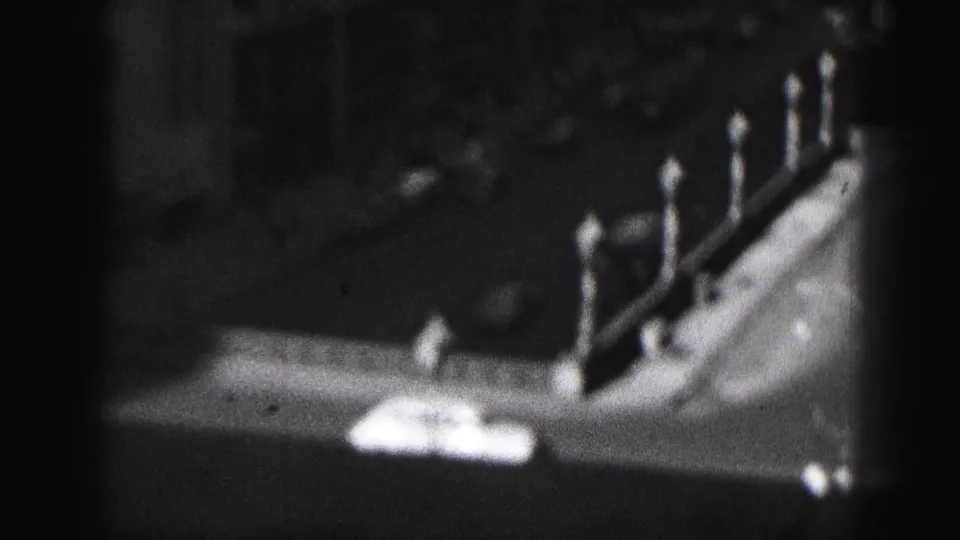 1946 Harrisburg 8mm frame looking down toward a street or roofline with evenly spaced globe-topped lampposts.