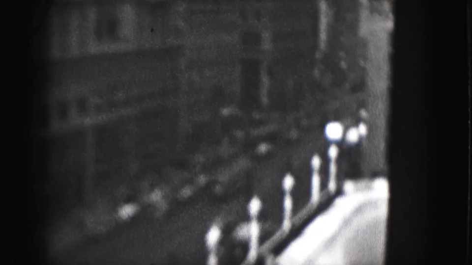 1946 Harrisburg 8mm frame with dark building facades and bright globe lampposts seen from an elevated angle.