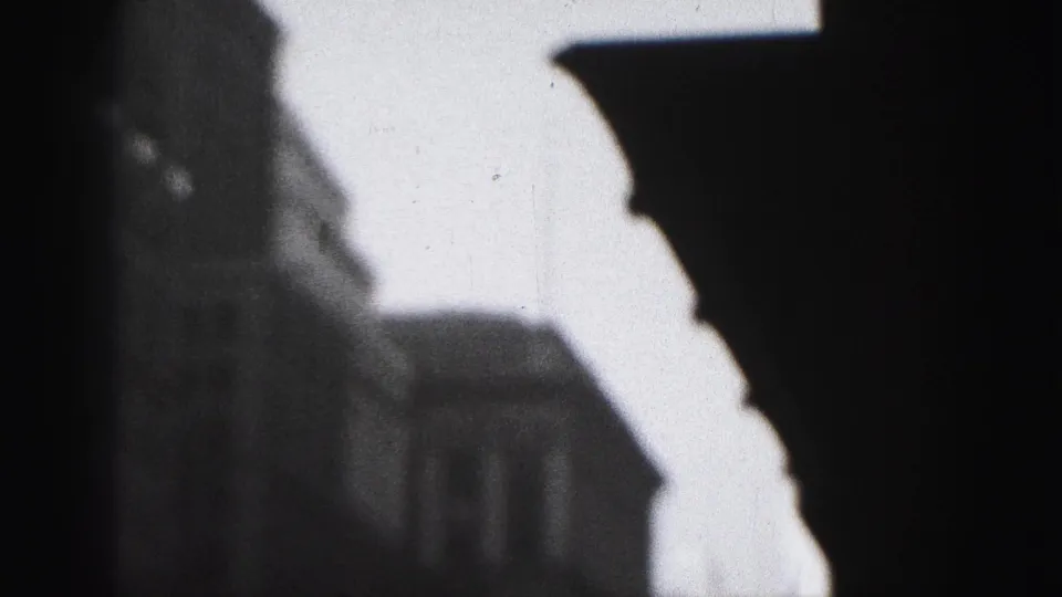 1946 Harrisburg 8mm frame with a bright vertical architectural edge, dark street-side building, and strong exposure contrast.