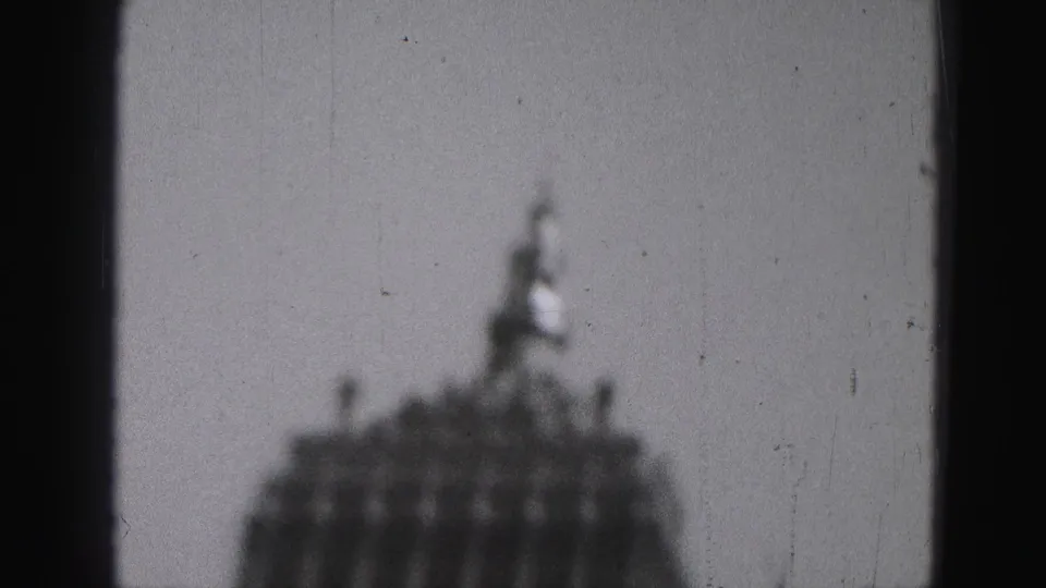 Blurred black-and-white view of a domed Harrisburg civic building seen from a moving vehicle window.