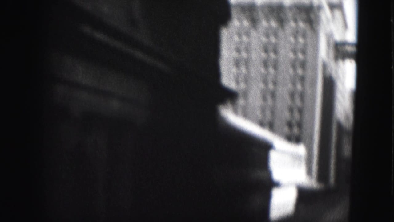Close shadowed building edge with a brighter windowed facade visible in the background.