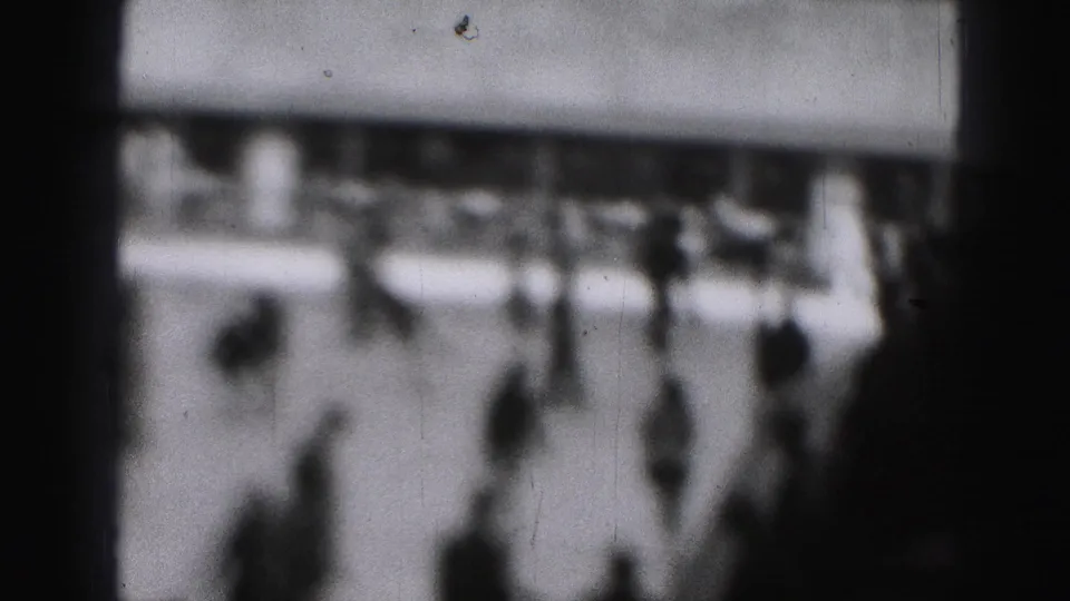 Final hazy frame of the Harrisburg skating rink scene with blurred people, rinkside background, and heavy 8mm grain.