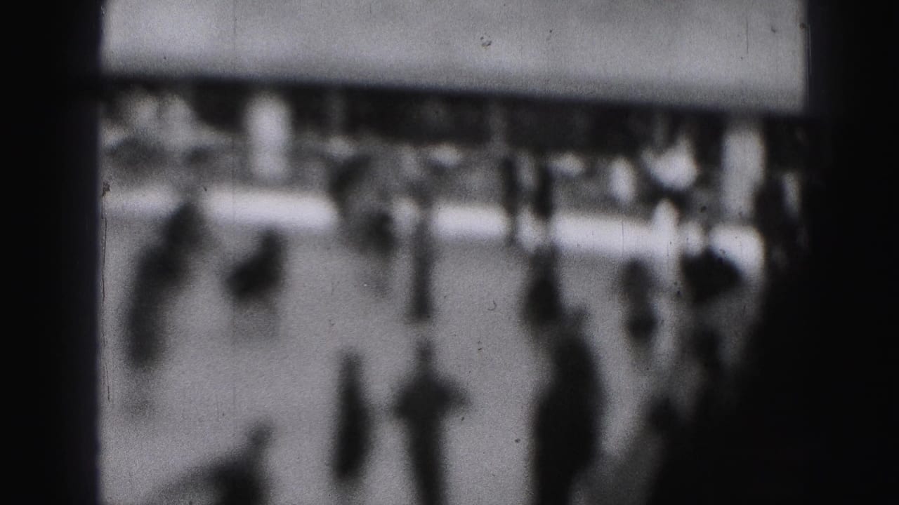 Soft-focus 1946 Harrisburg home-movie frame showing skaters and spectators on an outdoor ice surface.