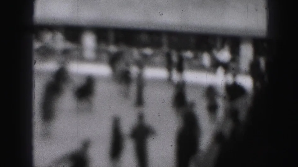 Soft-focus 1946 Harrisburg home-movie frame showing skaters and spectators on an outdoor ice surface.