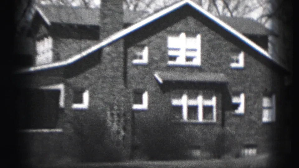 Harrisburg home exterior from 1946 metadata, centered on a steep gable, bright windows, porch roof, and grainy 8mm edges.