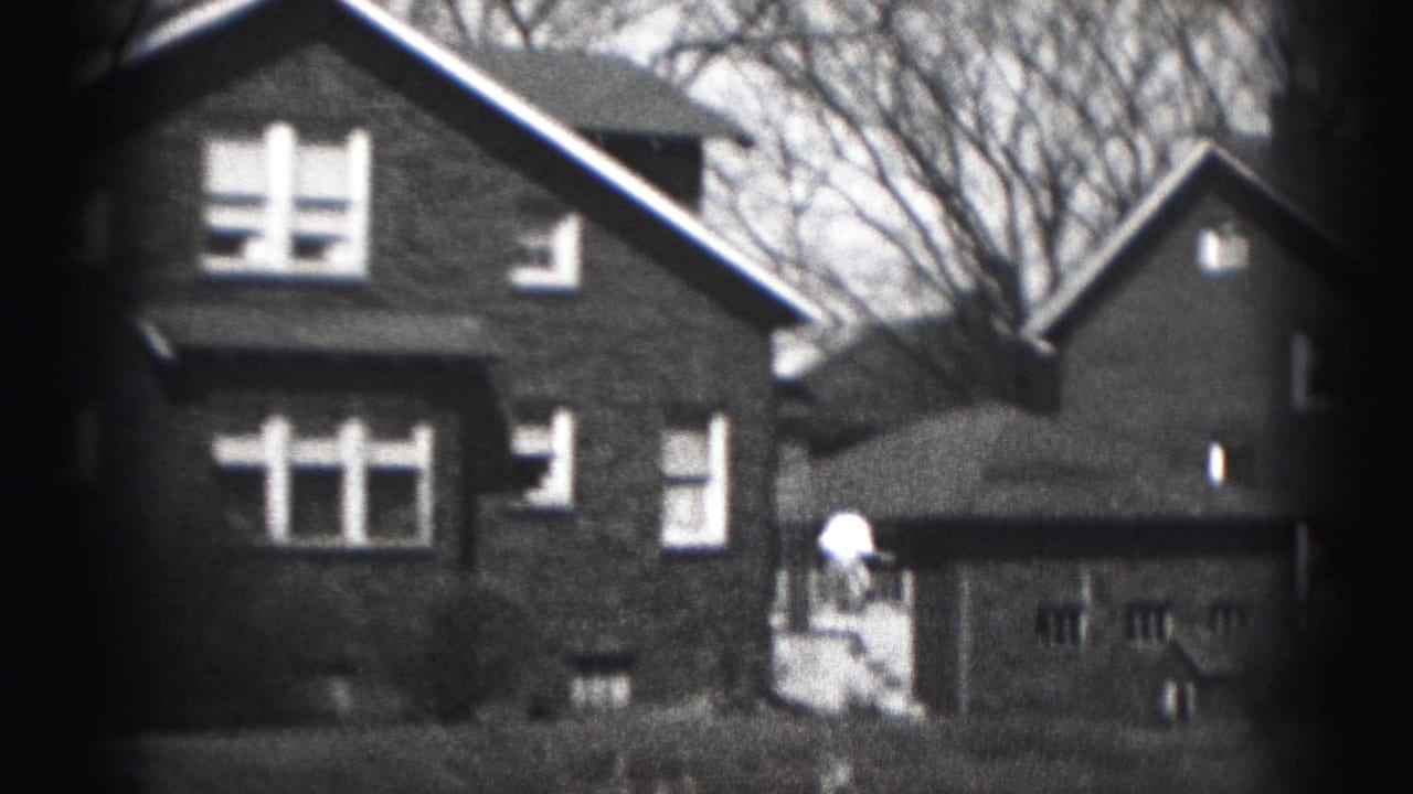 Brick house and detached garage beside a neighboring residential building.