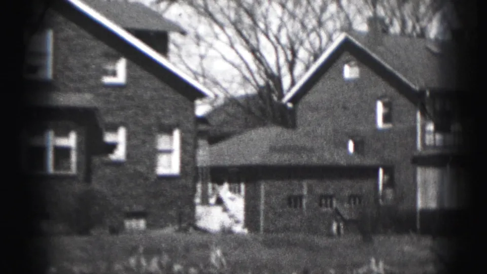 Harrisburg residential frame from 1946 showing adjacent brick houses, a detached garage, and bare tree branches.