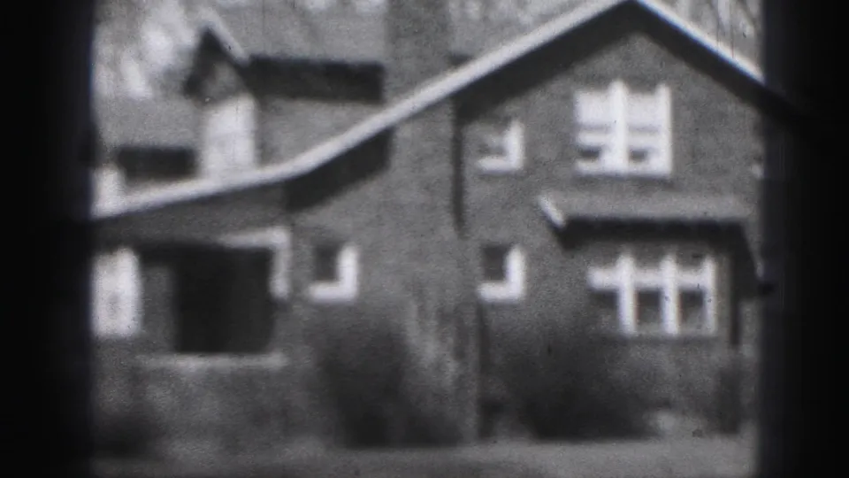 1946 Harrisburg frame showing the house from a slightly shifted angle, with porch roof, gable, windows, and soft 8mm blur.
