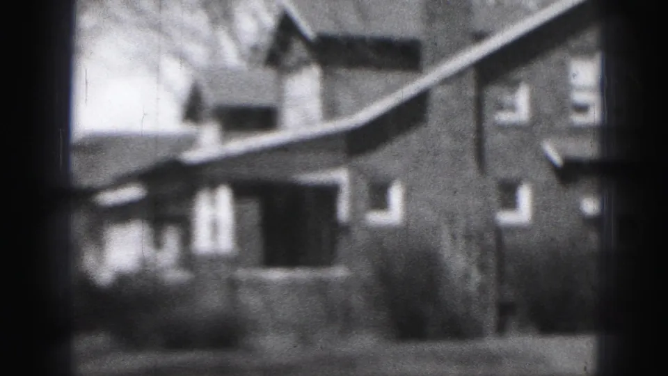 Final 1946 Harrisburg 8mm frame with a side-angled view of the house, porch opening, windows, shrubs, and heavy edge vignette.