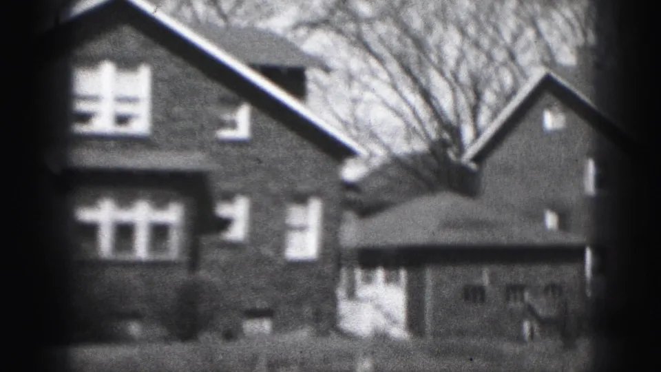 Final 1946 Harrisburg frame showing the brick house, a side or neighboring structure, bare trees, and softened 8mm frame edges.