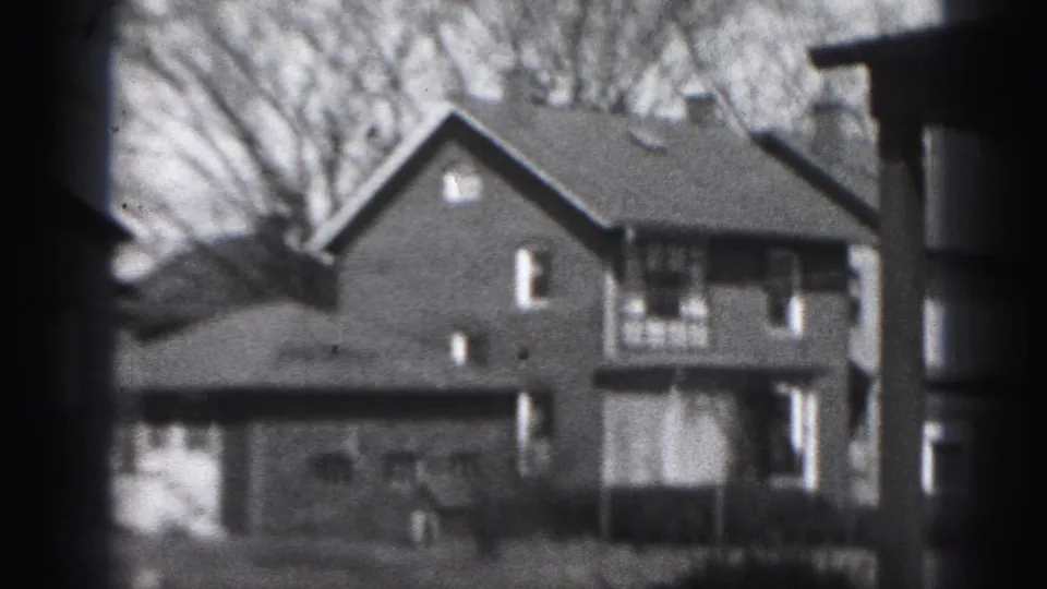 Black-and-white 8mm view of Harrisburg brick residences with rooflines, windows, and leafless trees, based on supplied 1946 location metadata.