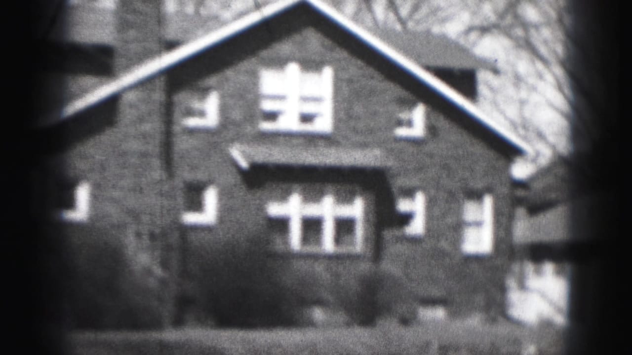 1946 Harrisburg home-movie view of a brick house facade with steep gable roof, chimney, and white-trimmed windows.