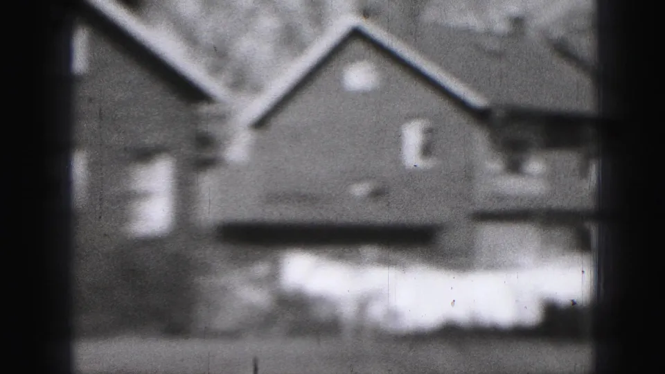 1946 Harrisburg frame showing laundry drying outdoors near a small house, with neighboring rooflines and trees visible.