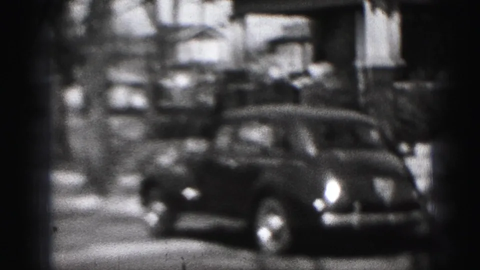 1946 Harrisburg home-movie frame showing a parked classic car beside residential houses and bare street trees.