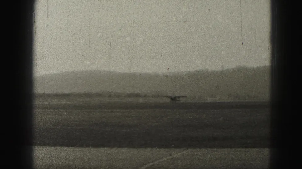 Small aircraft seen far across the runway in Harrisburg, Pennsylvania, with hazy hills in the background.